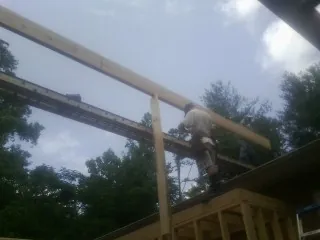 Carpenter setting a ridge beam over a new addition frame — Ice Dam Removal by Roofing Brothers in Pierz