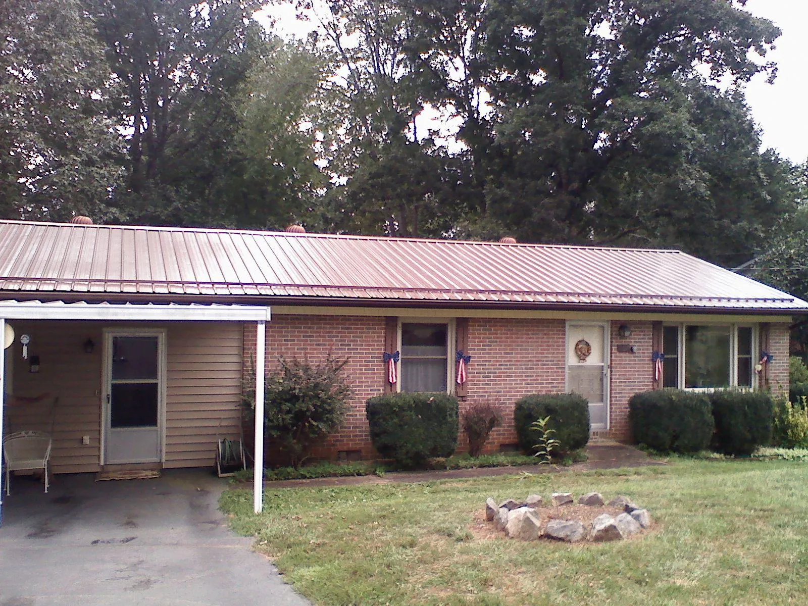Bronze metal roof and carport on a brick ranch home — Roof Repair work by our crew in Pierz